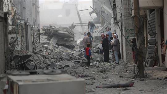 Menschen versammeln sich auf den Trümmern eines zerstörten Gebäudes nach einem Luftangriff im Flüchtlingslager Maghazi im Zentrum des Gazastreifens.
