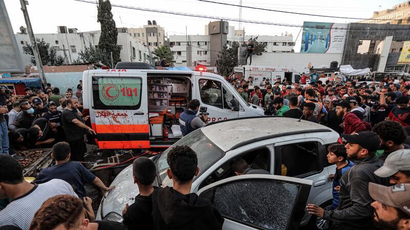 Menschen versammeln sich um einen Krankenwagen, nachdem dieser vor dem Eingang des Schifa-Krankenhaus angegriffen wurde.