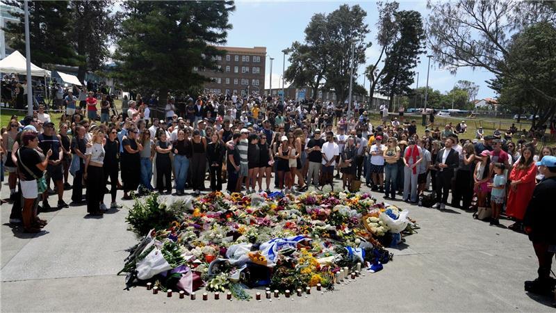 Menschen versammelt sich einen Tag nach einer Schießerei am Bondi Beach in Sydney um ein Blumendenkmal.