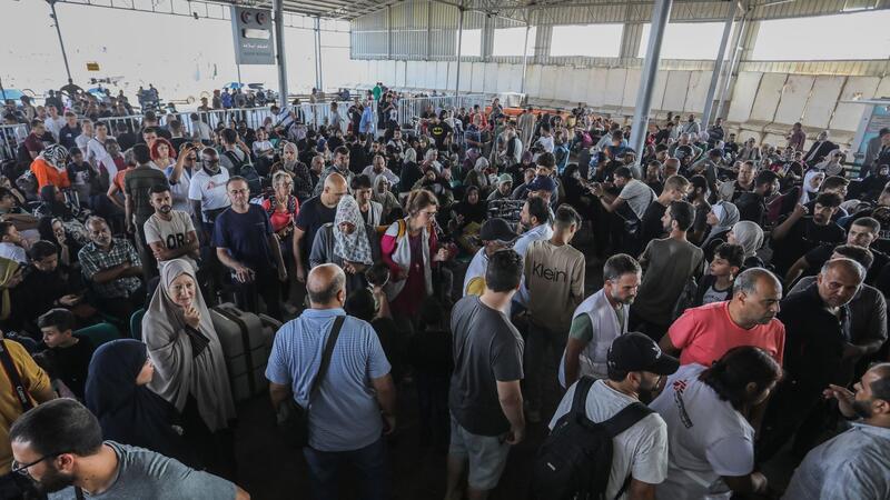 Menschen warten am Grenzübergang zwischen dem Gazastreifen und Ägypten.