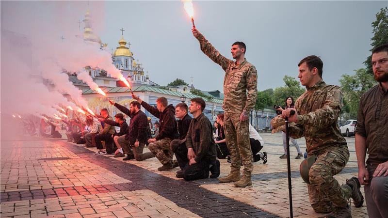 Menschen zünden Fackeln während der Beerdigungszeremonie für einen gefallenen ukrainischen Soldaten in Kiew.