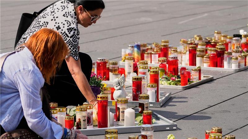 Menschen zünden auf dem Hauptplatz in Graz Kerzen zum Gedenken an die Opfer des Amoklaufs an einer Schule an. 