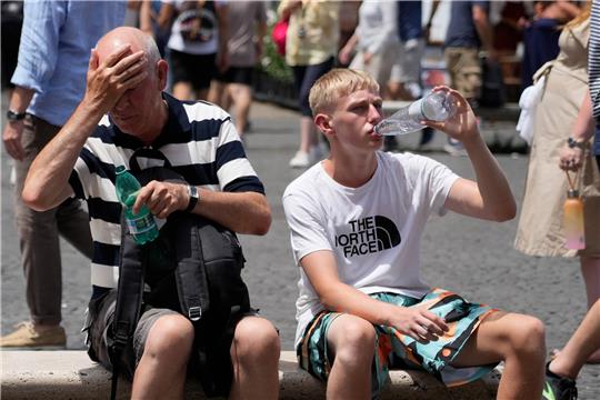 Menschen erfrischen sich mit Wasser. Im Kreis Stade sollen am Sonntag Temperaturen von bis zu 34 Grad erreicht werden. Foto: Gregorio Borgia/AP/dpa