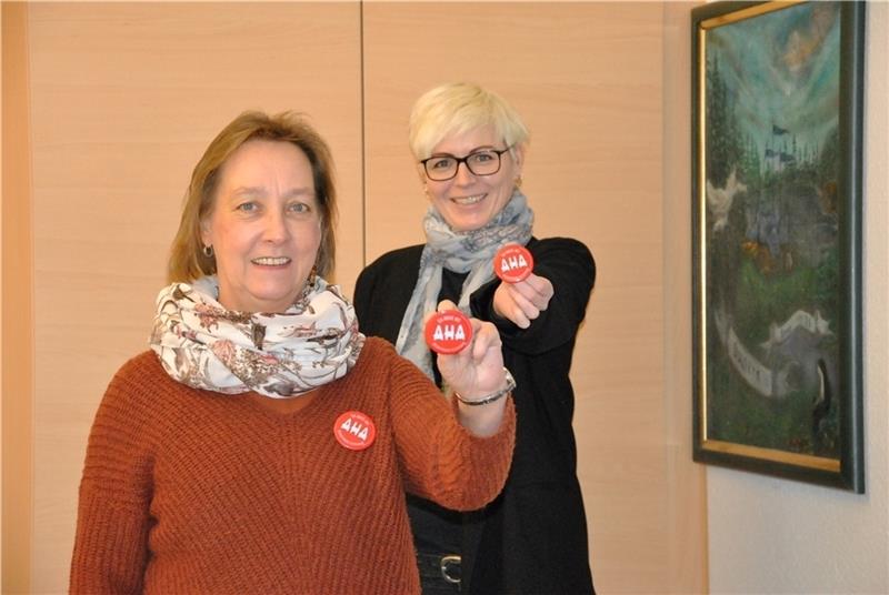 Mentorin und Mentee in Aktion: Bianka Lange (links) und Jennifer Barnes präsentieren ihre AHA-Buttons und halten dabei – hintereinanderstehend – den gebotenen Abstand von 1,5 Metern ein. Foto: Lohmann