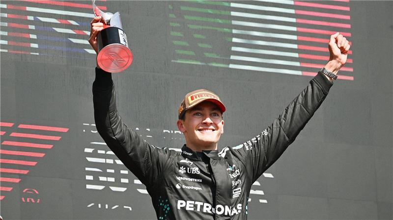 Mercedes-Pilot George Russell aus Großbritannien feiert seinen Sieg beim Grand Prix von Kanada und hält auf dem Podium seinen Pokal in der Hand.