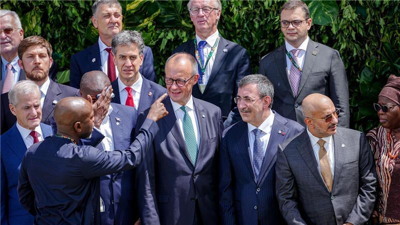 Merz stellt sich zum Familienfoto auf der COP30 auf.