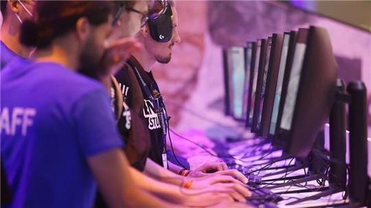 Messebesucher testen ein Computerspiel bei der Gamescom 2022. 