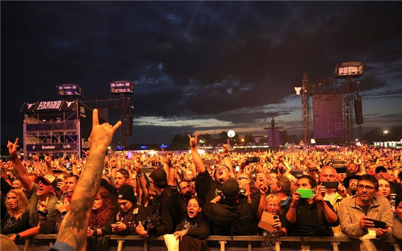 Metal-Fans feiern während eines Konzerts auf dem Festivalgelände.