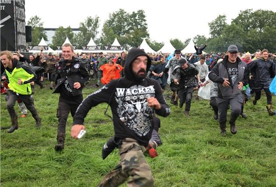 Metal-Fans freuen sich nach der Öffnung der Tore zum inneren Festivalgelände in Wacken. Foto: dpa