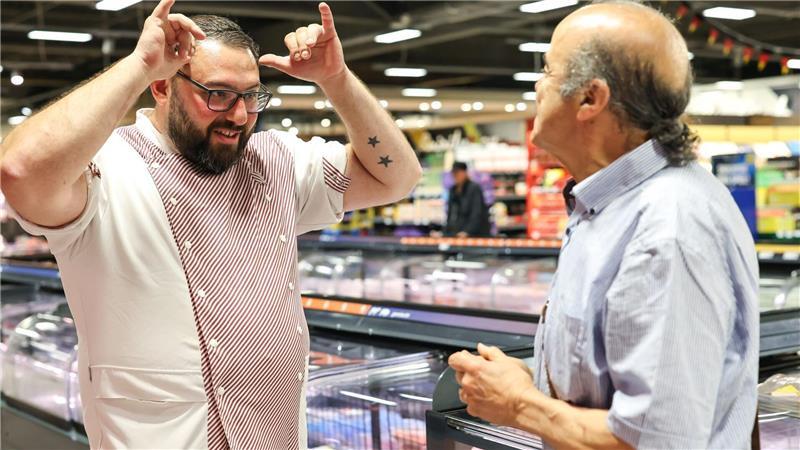 Metzger Yevgeniy Klibanov zeigt die Gebärde für „Rind“. 