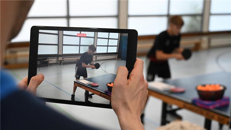 Michael Friebel richtet die Kamera auf einen jungen Spieler. Kurz danach betrachten sie den Bewegungsablauf auf dem Display.