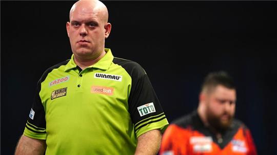 Michael van Gerwen (l) reagiert vor Michael Smith.
