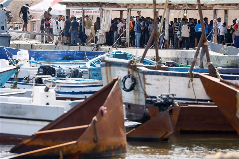 Debatte über Migrationsobergrenze - Rom beschließt Maßnahmen Migranten stehen an einem Hafen auf Lampedusa.