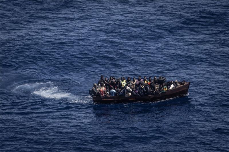 Tausende Bootsmigranten erreichen Lampedusa: Lager überfüllt Migranten steuern ein Boot in Richtung der Insel Lampedusa.