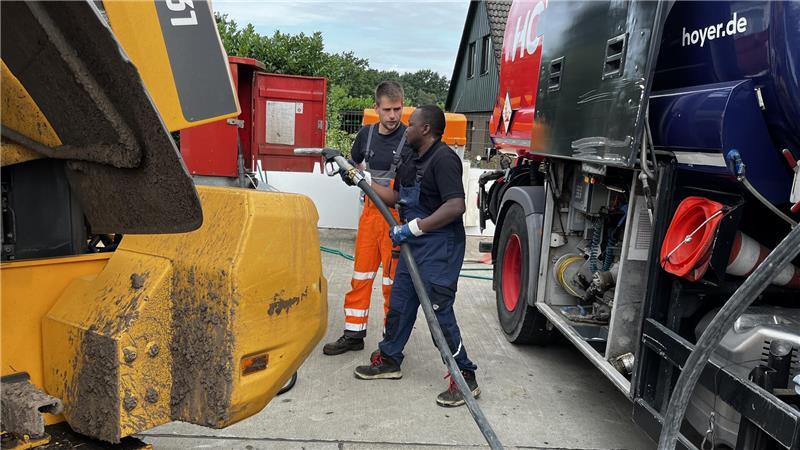 Mika Kroker tankt seinen Radlader mit Resten aus dem AWZ-Tank voll, damit Abdelkadeer Ali von der Tankfirma Hoyer ihn mit 1000 Litern Diesel befüllen kann.