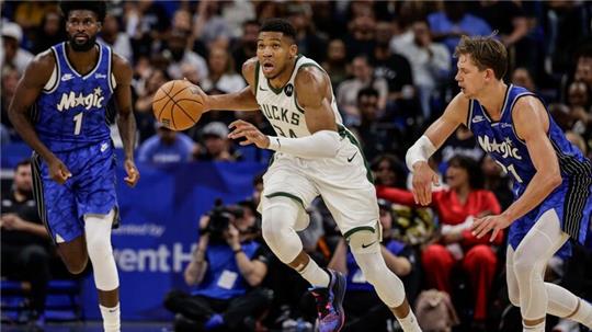 Milwaukees Giannis Antetokounmpo (M) dribbelt an Orlandos Jonathan Isaac (l) und Center Moritz Wagner (21) vorbei.