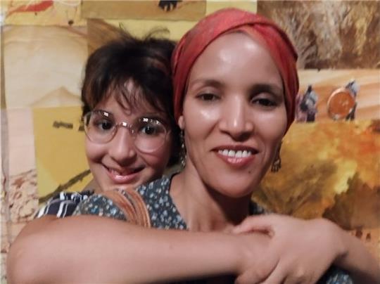 Mina Walet Omar Iken mit ihrer Tochter vor Fotos aus ihrer Heimat Mali.