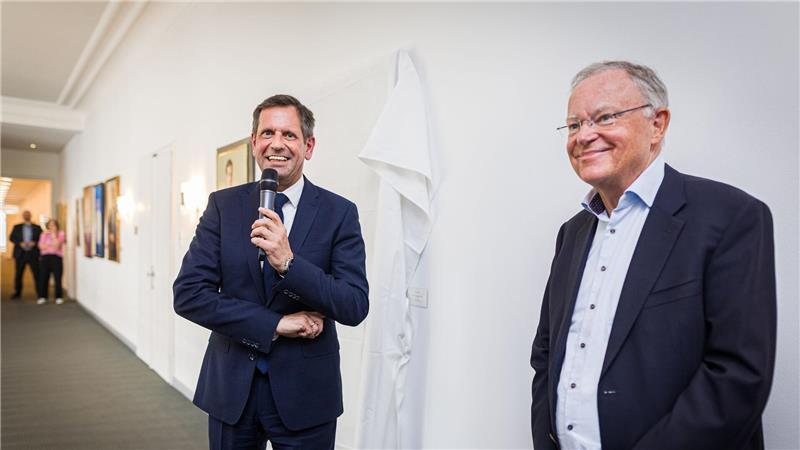 Ministerpräsident Olaf Lies (SPD, links) und dessen direkter Vorgänger Stephan Weil (auch SPD) stehen vor der Enthüllung des Porträts von Weil in der Niedersächsischen Staatskanzlei.