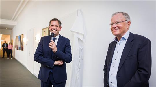 Ministerpräsident Olaf Lies (SPD, links) und dessen direkter Vorgänger Stephan Weil (auch SPD) stehen vor der Enthüllung des Porträts von Weil in der Niedersächsischen Staatskanzlei.