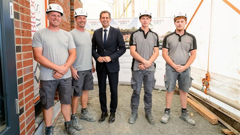 Viebrockhaus: Im Altländer Viertel entsteht Stades erste Smart-City Ministerpräsident Olaf Lies mit einer Maurerkolonne von Viebrockhaus. In nur vier Monaten wird das erste der 14 Power Townhouses bezugsfertig sein.