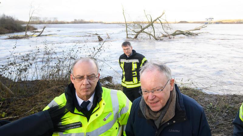 Ministerpräsident Stephan Weil (rechts, SPD), und Dieter Rohrberg, Landesbranddirektor Niedersachsen, stehen vor einem gebrochenen Damm an der Ruhme bei Northeim.