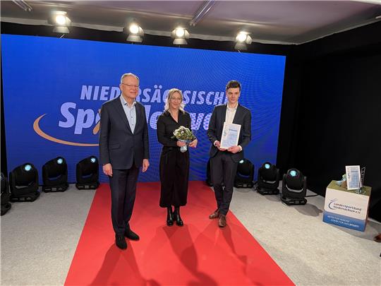 Ministerpräsident Stephan Weil verkündet den Sieger . Gesa Bührig und Malte Möller (rechts) nehmen die Auszeichnung entgegen. Foto: LSB/Jüttner