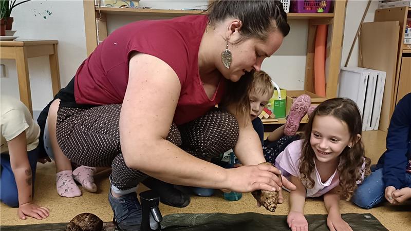 Miriam Scheer-Garowski setzt Karla eine Achatina, eine afrikanische Riesenschnecke, auf die Hand.