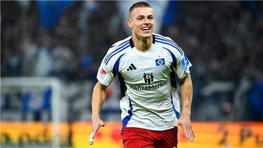 Miro Muheim im weißen HSV-Heimtrikot rennt und jubelt.