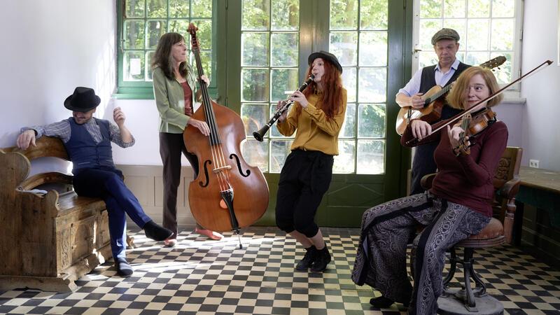 Die fünf Musiker von Mischpoke in einem historischen Gebäude mit einem Boden im Schachbrettmuster