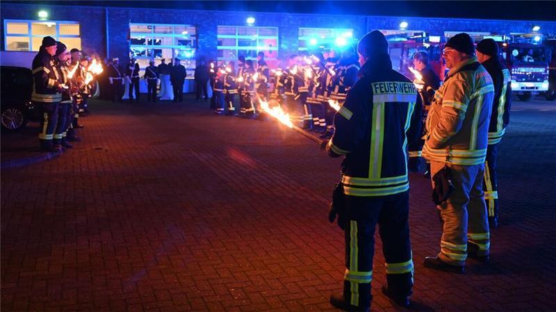 Konvoi durch den Kreis Stade: Kreisbrandmeister feiert emotionalen Abschied Mit Fackeln bilden Einsatzkräfte der Kreisfeuerwehrbereitschaft Nord in Wiepenkathen vor der Feuerwehrtechnischen Zentrale ein Spalier.
