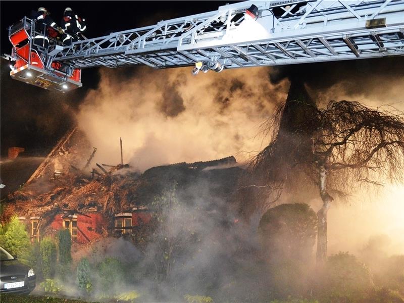 Mit Hilfe der Drehleiter aus Stade bekämpften die Feuerwehrleute die immer wieder aufflackernden Glutnester im Reetdach. Foto Kordländer
