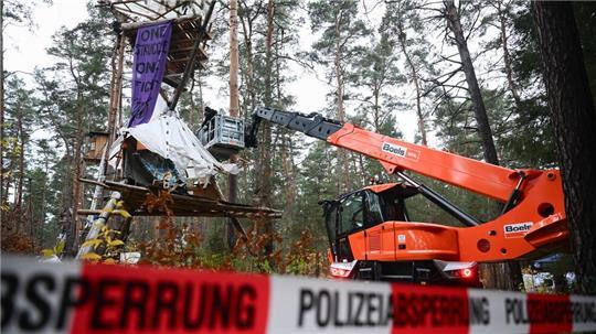 Mit Hilfe einer Hebebühne kommen die Polizeikräfte an die Baumhäuser im aufgelösten Tesla-Protestcamp heran.