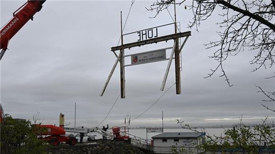 Mit Hilfe eines Schwerlastkrans wird das Tor zum Landkreis Stade am Lühe-Anleger in Grünendeich demontiert.