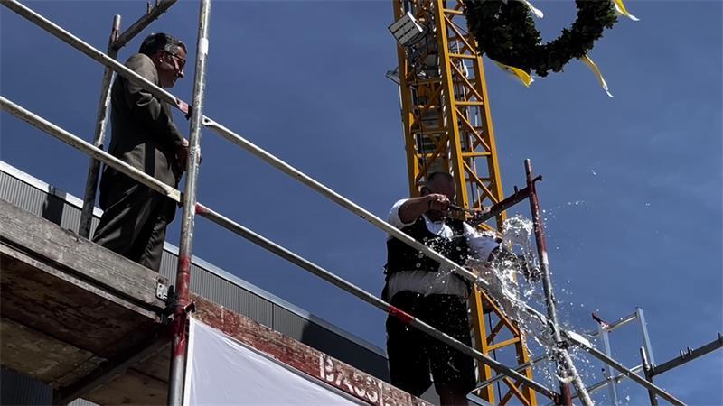 Mit Kai Seefried für den Landkreis Stade als Bauherrn hat Zimmermann Axel Hink den Neubau kräftig begossen - natürlich mit einem zünftigen Spruch.