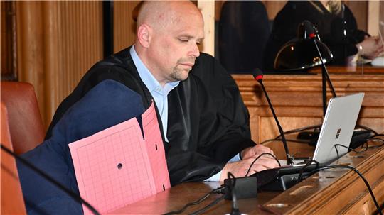 Mit Kapuze und Mappe versteckt sich der Angeklagte geradezu im Gerichtssaal, als er auf der Anklagebank Platz nimmt. Sein Anwalt Alexander Ukat ist ein erfahrener Strafverteidiger. Foto: Mündelein