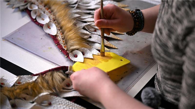 Mit Pinsel und goldener Farbe bemalt Toni ihr Kostüm. 