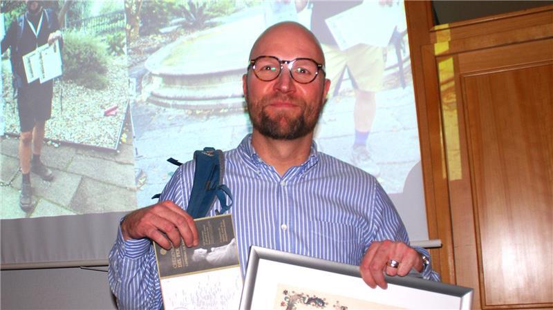 Mit Rucksack, Pilgerpass und Urkunde: Dennis Tiedemann-Harder hatte in Apensen auch Tipps zum Pilgern im Gepäck.