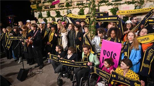 Mit Schals und Schildern haben Prominente an einer Protestaktion von SOS Humanity teilgenommen.