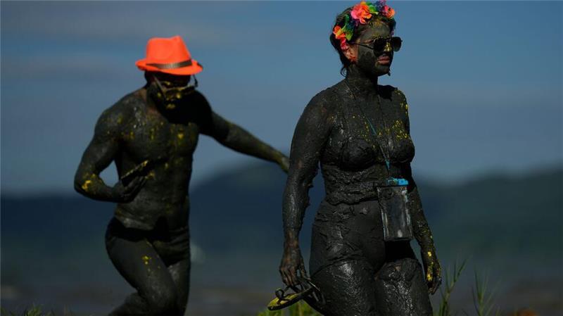 Mit Schlamm beschmierte Feiernde besuchen die Mud Block Karnevalsparty in Paraty, Brasilien.