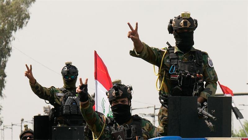 Mit Siegeszeichen: Irakische Sicherheitskräfte fahren in einem Konvoi durch die irakische Hauptstadt, um den vollständigen Abzug der US-Truppen aus dem Irak zu feiern.