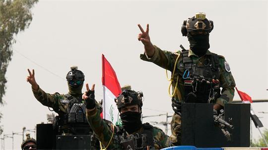 Mit Siegeszeichen: Irakische Sicherheitskräfte fahren in einem Konvoi durch die irakische Hauptstadt, um den vollständigen Abzug der US-Truppen aus dem Irak zu feiern.