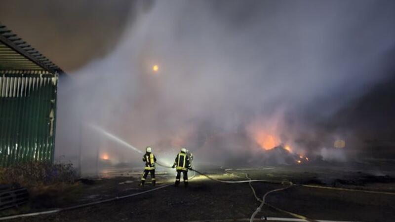Mit Wasser kämpfen die Feuerwehrleute gegen die Flammen an.