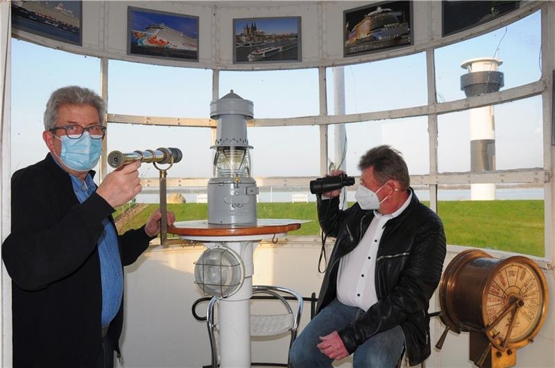 Mit alten und neuen Ferngläsern können Hans-Heinrich Faby (links) und Jochen Steffens vom Lampenhaus aus den Verkehr auf der Elbe beobachten, der jetzt von dem geringelten Leuchtturm (rechts) Lichtzeichen erhält. Fotos: Lankuttis