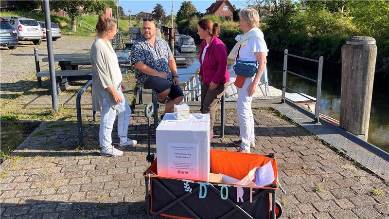 Mit dem Bollerwagen zogen Anne Rosenfeld, Nikolai Müller, Sonja Zinke und Ulrike Mohr 2024 durch die Ortschaften und sammelten Ideen für die Dorfregion „Um die Lühe“ aus Steinkirchen, Grünendeich und Hollern-Twielenfleth - auch am Hafen in Steinkirchen.