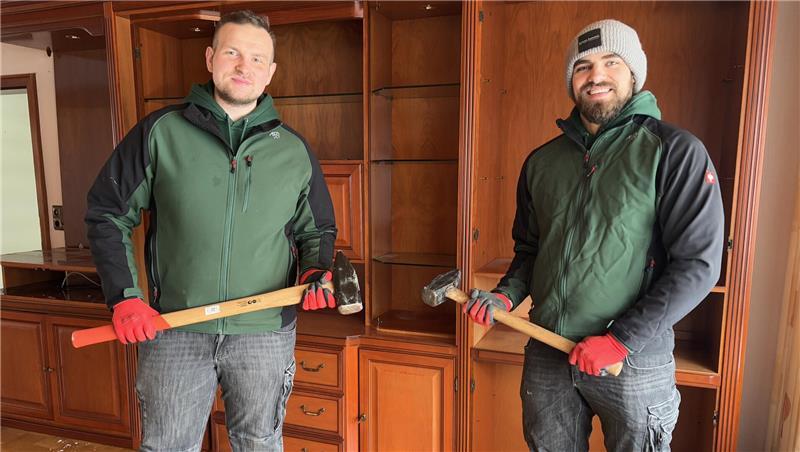 Mit dem Vorschlaghammer schlagen Niklas Pontow (rechts) und Meik Mroz gleich den Schrank im Hintergrund ein.
