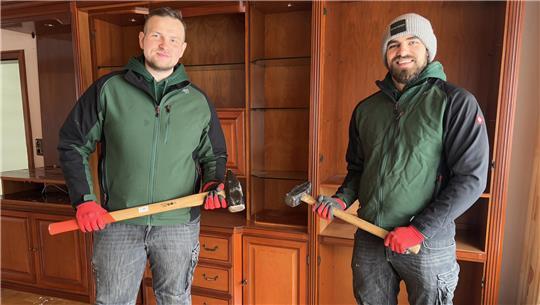 Mit dem Vorschlaghammer schlagen Niklas Pontow (rechts) und Meik Mroz gleich den Schrank im Hintergrund ein.