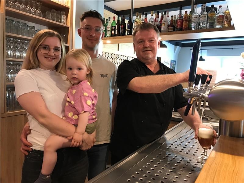 Mit dem neuen Tresen macht das Bierzapfen noch mehr Spaß: Gastwirt Heiko Sieb (rechts) mit Tochter Alexandra und Schwiegersohn Jan Zabel und Enkelkind. Fotos: Helfferich