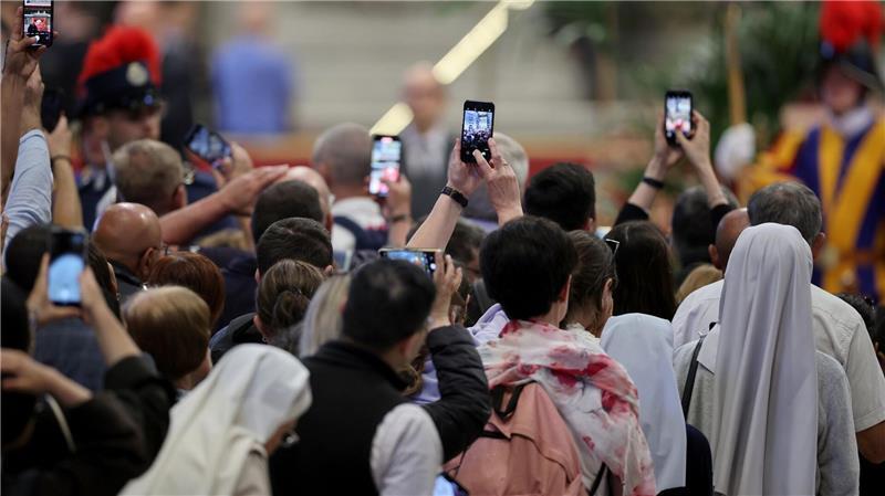 Mit den Smartphones machen Gläubige ein Foto vom toten Papst.