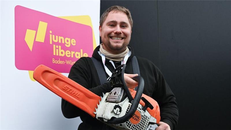 Nur wenige Wähler rechnen mit Wirtschaftswende nach der Wahl Mit der Kettensäge will Mark Hohensee, Landesvorsitzender der Jungen Liberalen, packt für den Bürokratieabbau symbolisch die Kettensäge aus.