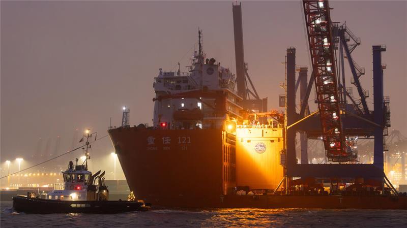 Mit drei Containerbrücken beladen fährt das Transportschiff „Zhong Ren 121“ durch den Hamburger Hafen.